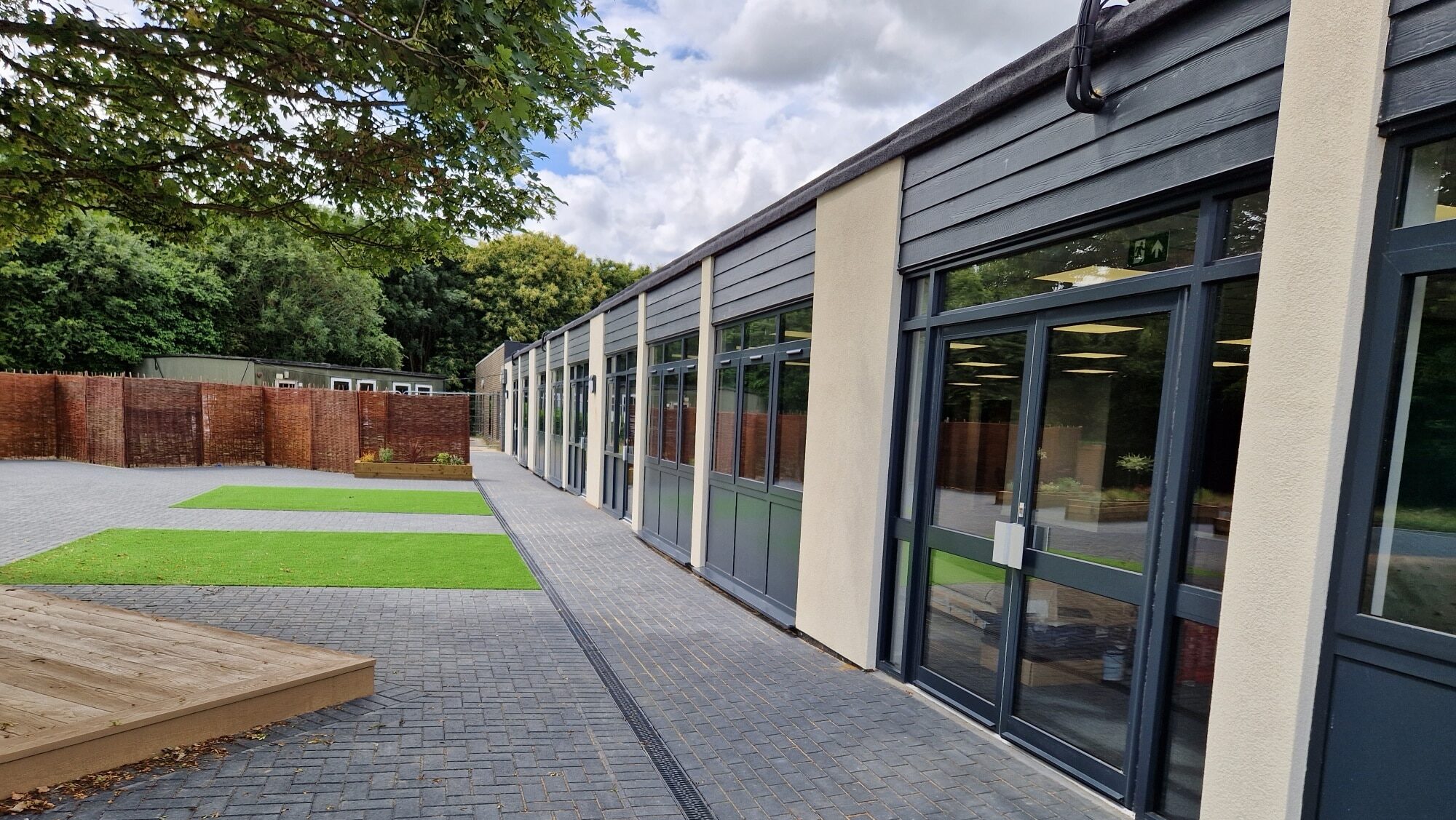 Single storey, modern building with paved palyground outside