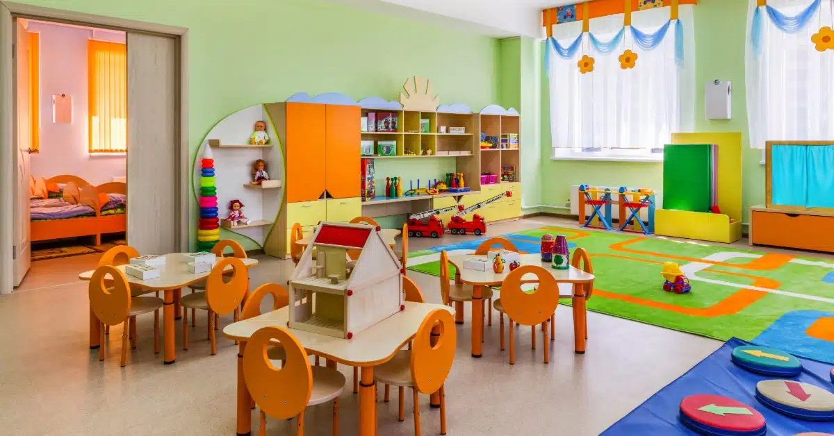 Brightly coloured nursey room filled with tables and toys