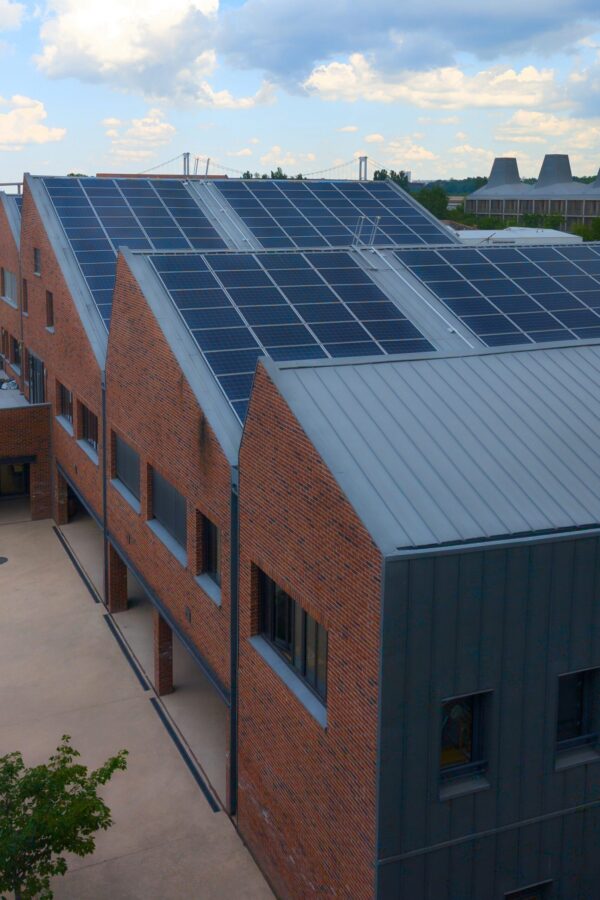 large solar panel on office building topped with roof array amidst city structures of energy in urban town area