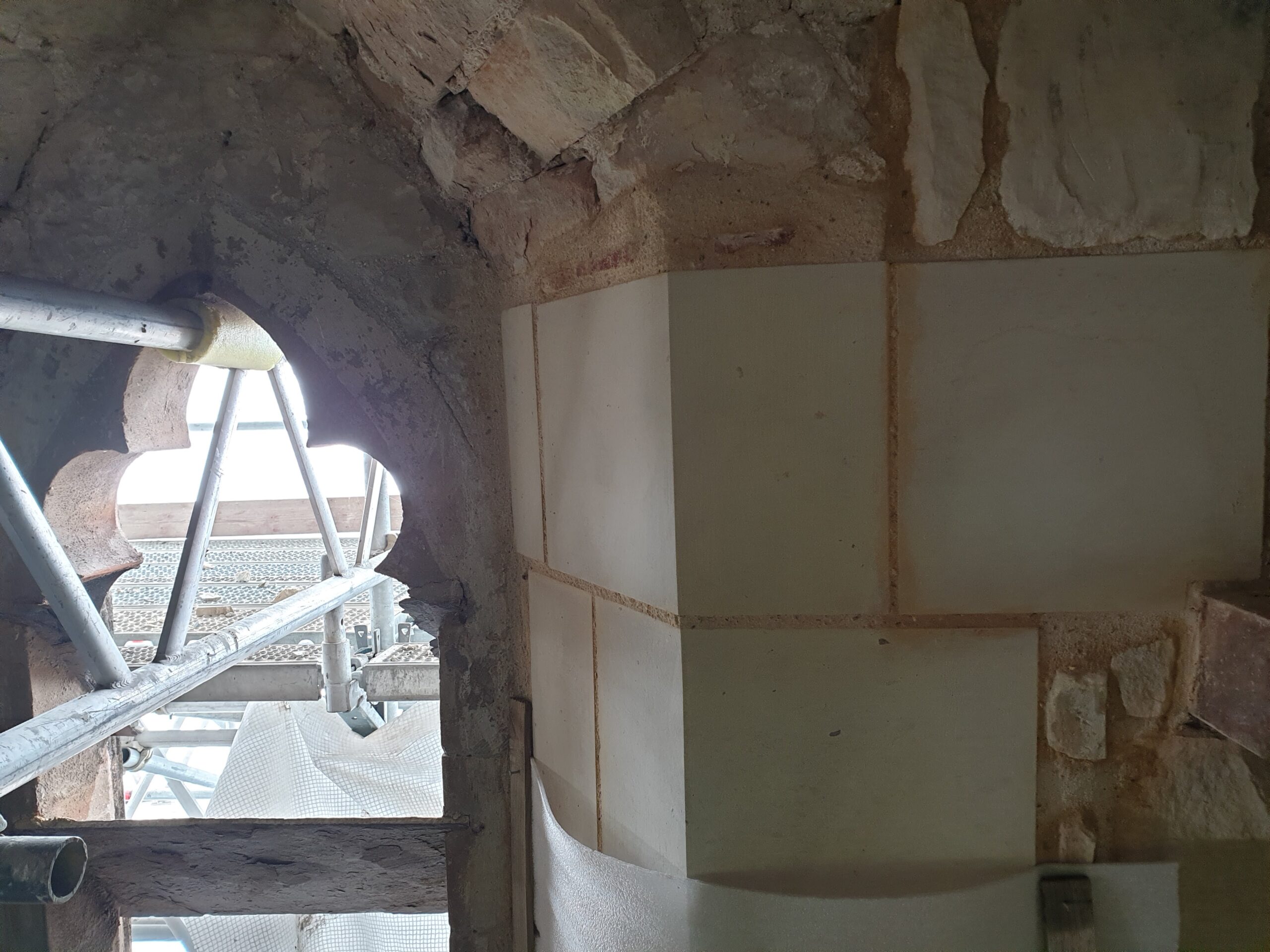 Close up on the stone walls of St John The Baptist's Church with a window to the left