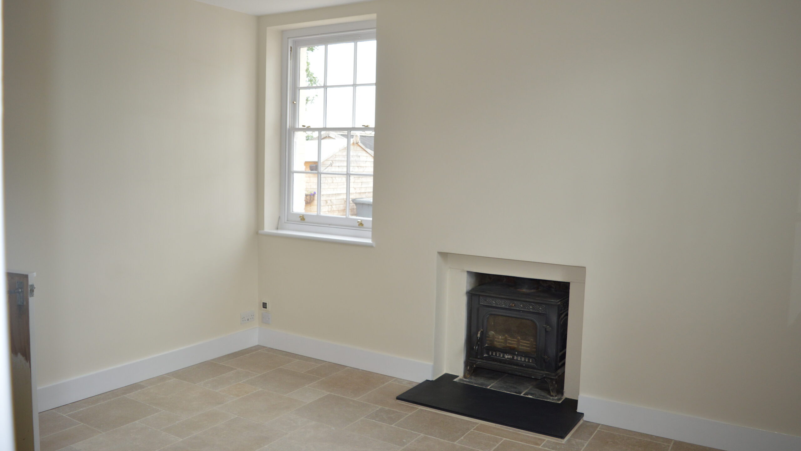 Finished dining room with cream walls, fireplace, and tiled floor