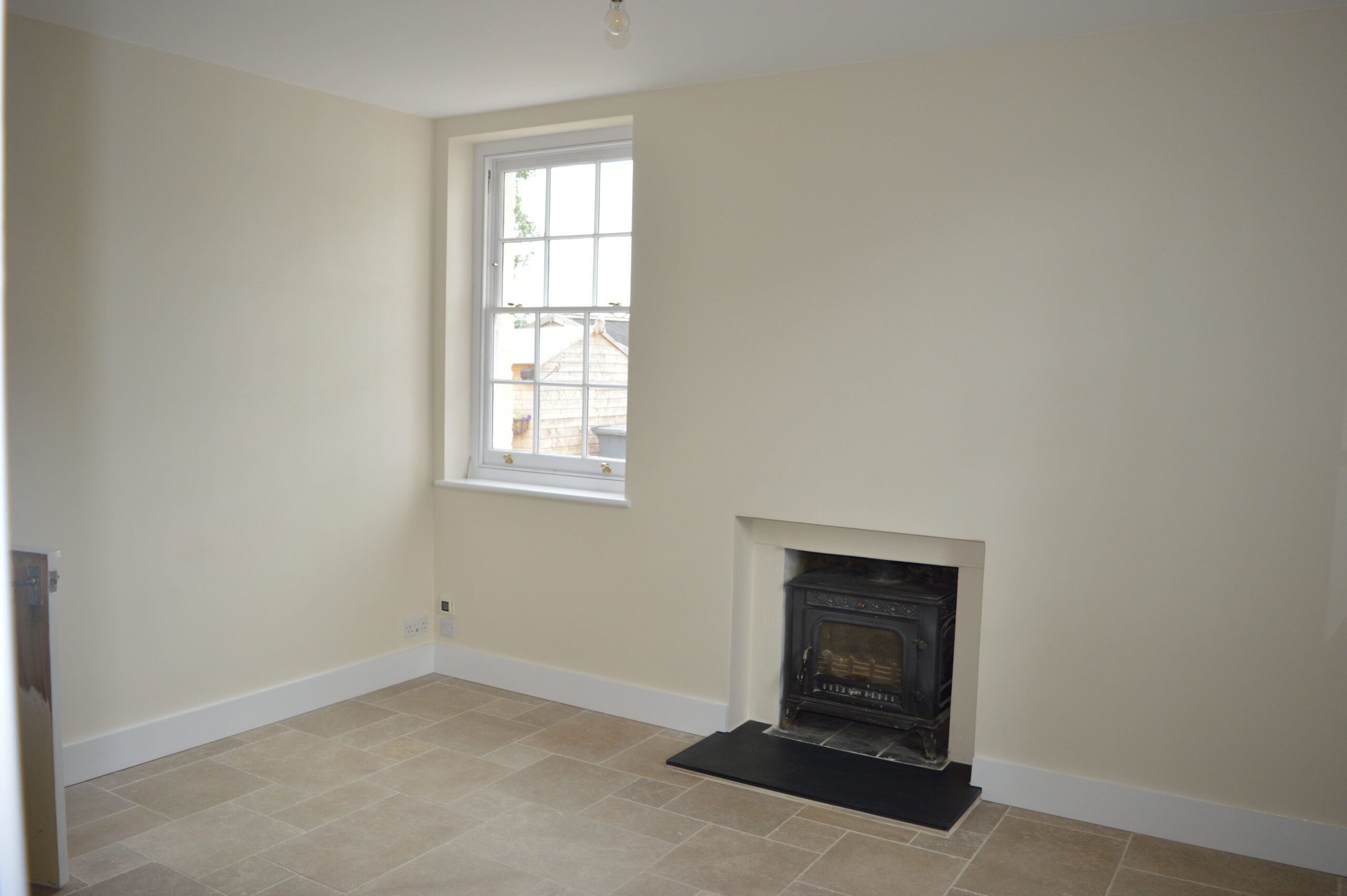 Finished dining room with cream walls, fireplace, and tiled floor